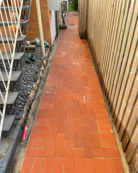 After: red brick paved path between the house and the timber fence