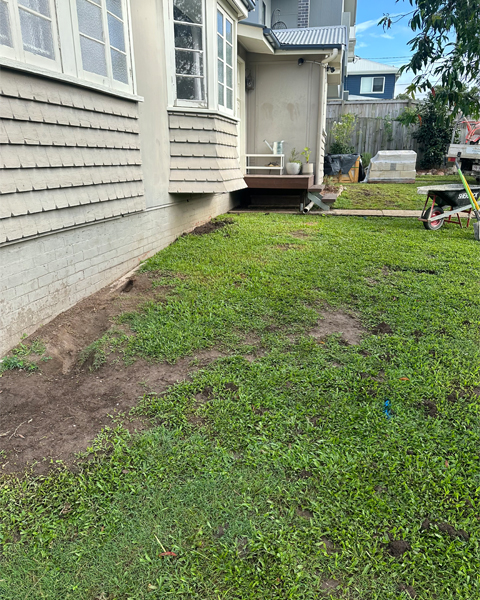 Before: grassy side yard beside a weatherboard house